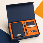 Open navy executive corporate gift box with PU notebook, metal pen, business card holder and keychain arranged on an orange insert.