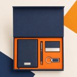 Top view of a navy gift box with notebook, pen, card holder and keychain.